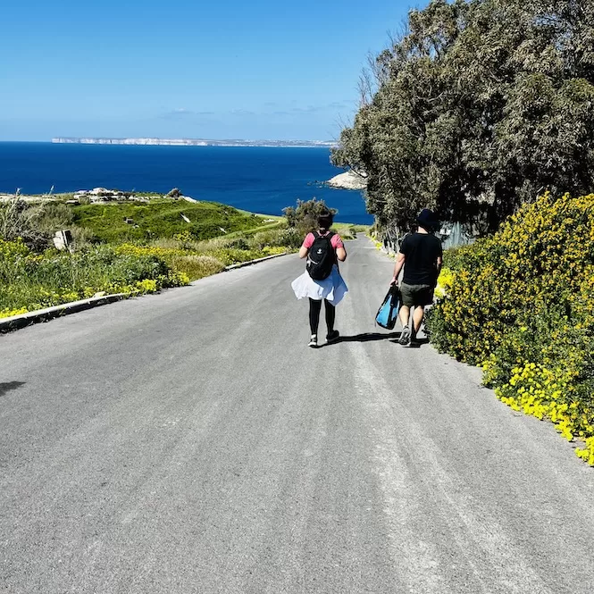 People walking along a scenic road in Malta and Gozo.