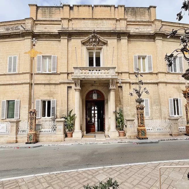 A grand entrance to Palazzo Parisio, a historic palace located in Naxxar, Malta, featuring ornate architecture and decorative elements.