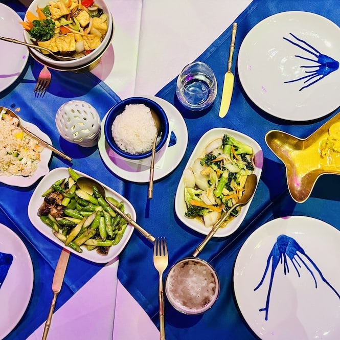 A table set with various Thai dishes at the Blue Elephant restaurant in St. Julians Portomaso. The dishes include stir-fried vegetables, rice, and other Thai delicacies.