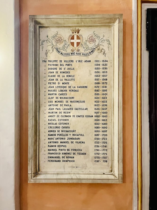 A framed list mounted on an interior wall of the Grandmaster's Palace in Valletta, Malta, showing the names and dates of Grand Masters who ruled over Malta from 1530 to 1798 under the Order of St. John.