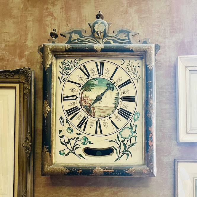 Ornate antique wall clock with decorative frame and floral designs at Cassa Rocca Piccola in Valletta.