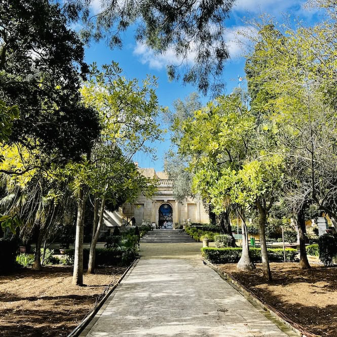 Grand pathway leading to ornate building in San Anton Gardens, a historic Malta tourist destination.