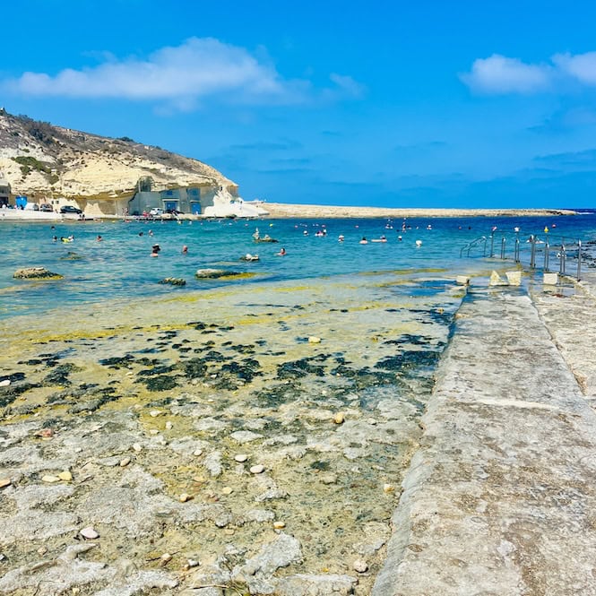 A panoramic view of Xwejni Bay showcasing its beautiful coastline and clear blue waters in Gozo.