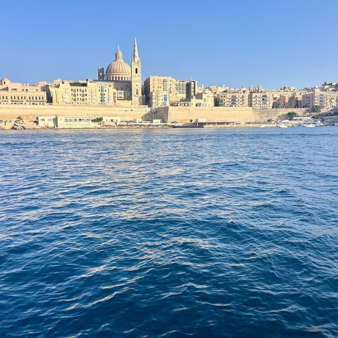 View of the historic city of Valletta, Malta, from the sea, featuring iconic architecture, highlighting a must-do experience of taking a ferry ride.