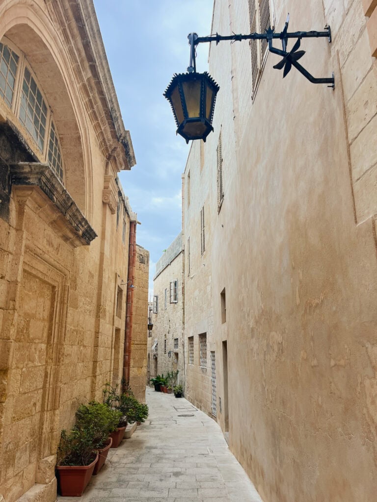 Narrow alley in Mdina, Malta with old stone buildings, suitable for slow and wheelchair accessible travel Malta