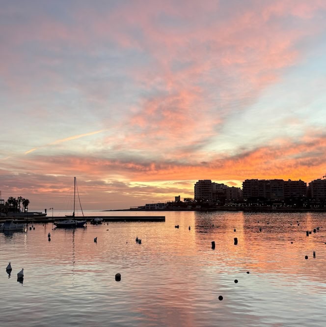 Soft sunrise over St Julian’s Bay in Malta, with calm waters and boats – a peaceful early walk that’s one of the most romantic things to do in Malta for couples.